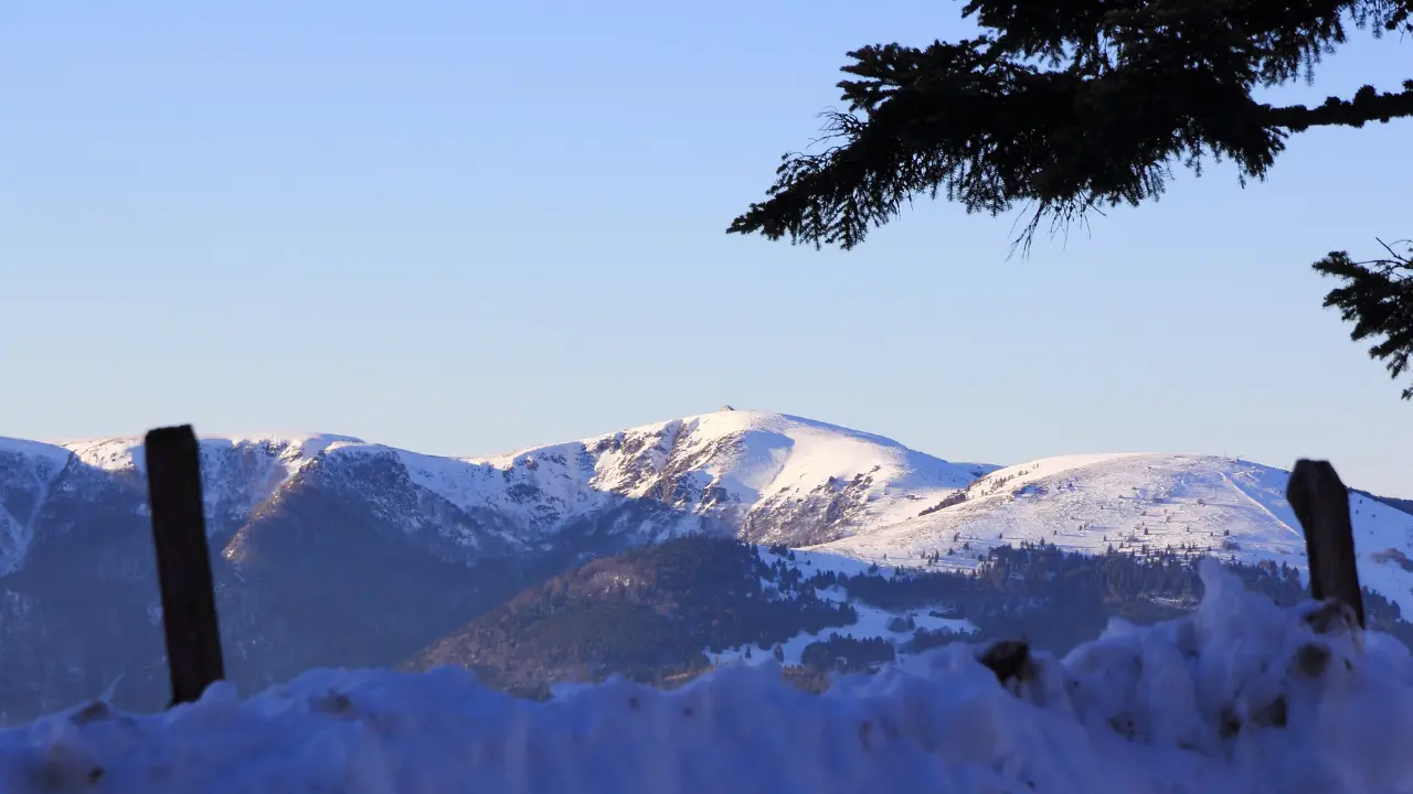 Paysage des Vosges en hiver avec montagnes enneigées et forêts, illustrant un week-end dans les Vosges et les itinéraires à découvrir en 2026.