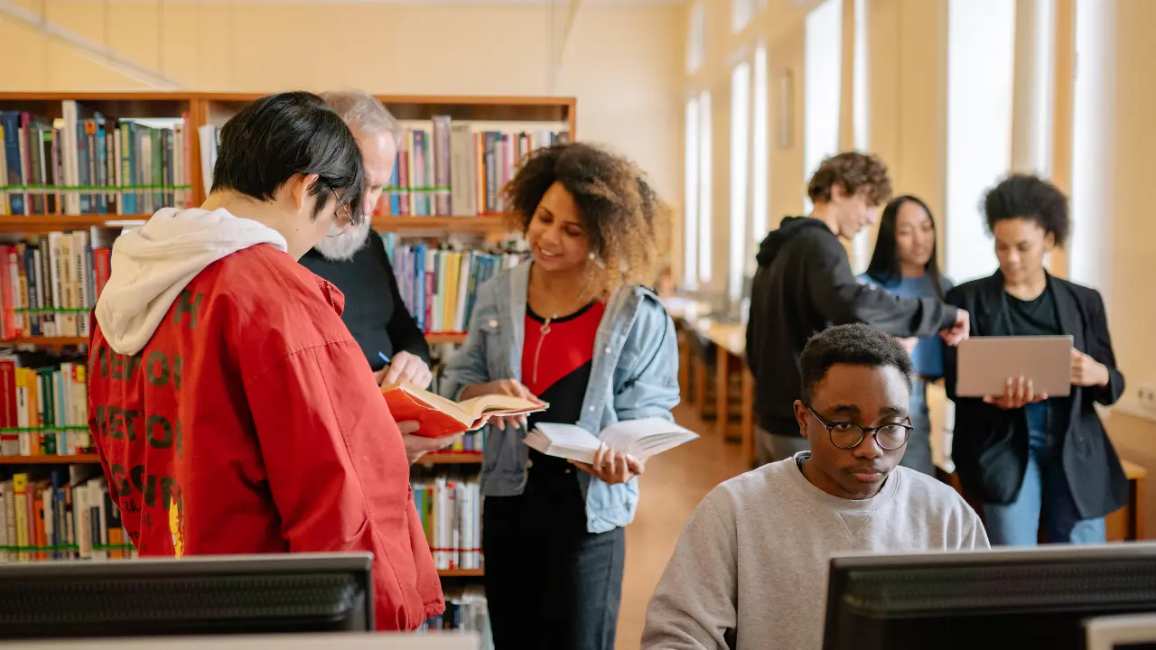 Groupe de visiteurs dans une ludothèque à La Bresse, consultation de jeux et livres, espace convivial pour familles et enfants en 2026.